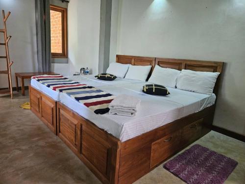 a large bed with a wooden frame in a bedroom at Thehideout kurunegala in Kurunegala