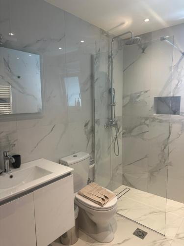 a bathroom with a shower and a toilet and a sink at Rodos Suites on the Park in Rhodes Town