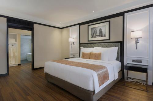 a bedroom with a large bed and a bathroom at Meliá Kuala Lumpur in Kuala Lumpur