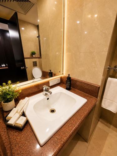 a bathroom with a white sink and a mirror at Hotel Cymbal -Sector 31 Gurgaon in Gurgaon