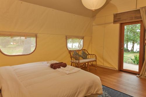 a bedroom with a bed with a teddy bear on it at The Woods Beachfront Tent Yao Noi in Ko Yao Noi