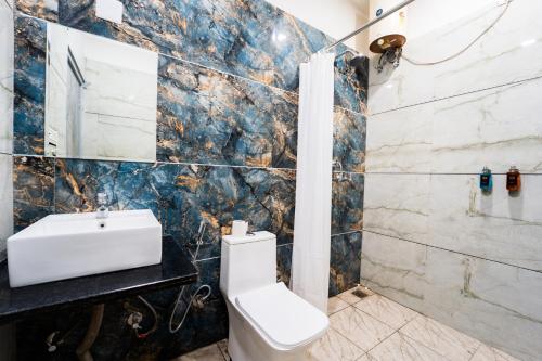 a bathroom with a toilet and a sink at Hotel Aura in Bikaner