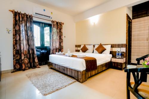 a bedroom with a large bed and a window at The Mint Calangute in Calangute