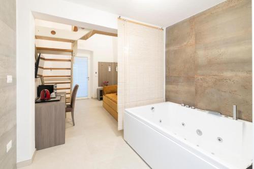 a bathroom with a bath tub and a bedroom at Vie Del Salento in San Pancrazio Salentino