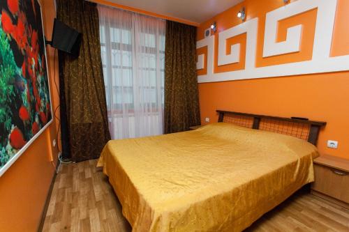 a bedroom with a bed with an orange wall at U Igorya Holiday Park in Alushta