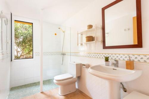 a white bathroom with a sink and a toilet at Villa Aries by 3VILLAS in Cala en Forcat