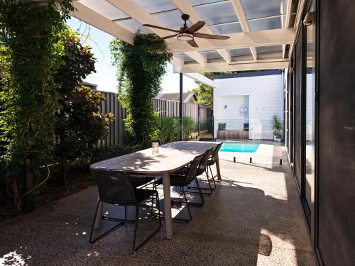 a patio with a table and chairs and a pool at Maple & Rubus, Berry - by Linnaeus Collection in Berry