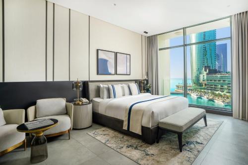 a bedroom with a large bed and a large window at Charthouse Bahrain in Manama