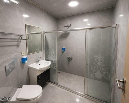 a bathroom with a shower and a toilet and a sink at Grand Mardin Hotel in Mersin