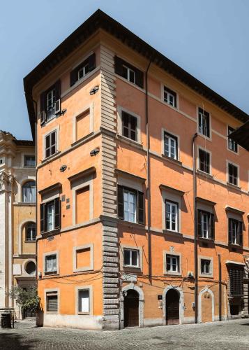 a large orange brick building with windows at Limehome Rome Trastevere in Rome