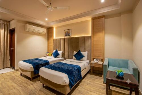 a hotel room with two beds and a chair at The Waves Hotel with Free Airport Pickup or Drop in New Delhi