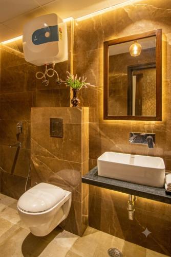 a bathroom with a toilet and a sink and a mirror at The Waves Hotel with Free Airport Pickup or Drop in New Delhi