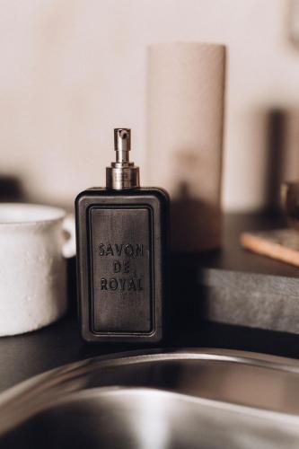 a soap dispenser sitting on top of a sink at Maruse's Apartment in Kuldīga