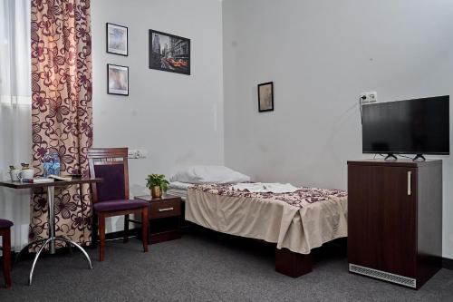 a hotel room with a bed and a television at Hostel Evotel in Zielonka