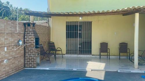a patio with chairs and a pool in a house at MT Laser casa 2 in São José da Coroa Grande