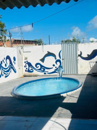 a fountain in a pool in front of a wall at MT Laser casa 2 in São José da Coroa Grande
