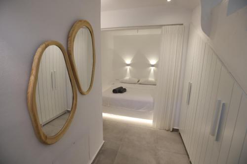 a bathroom with a mirror and a bed in a room at Liotrivi Luxury Residences in Kithnos
