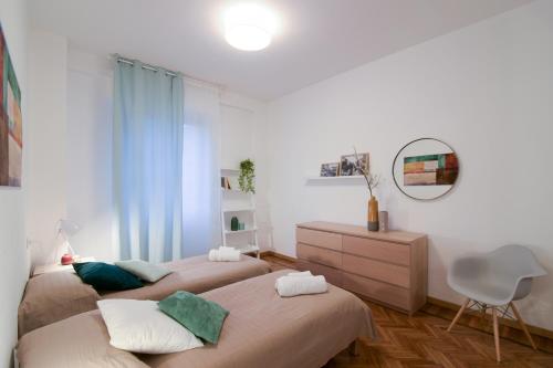 ミラノにあるThe Best Rent - Milan Cimiano Apartmentのベッドルーム1室(ベッド2台、ドレッサー、鏡付)