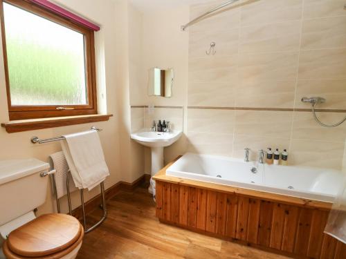 a bathroom with a tub and a sink at Thistle Do in Lochailort