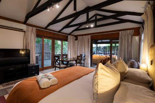 a bedroom with a large bed and a living room at Sand River Guest House in Johannesburg