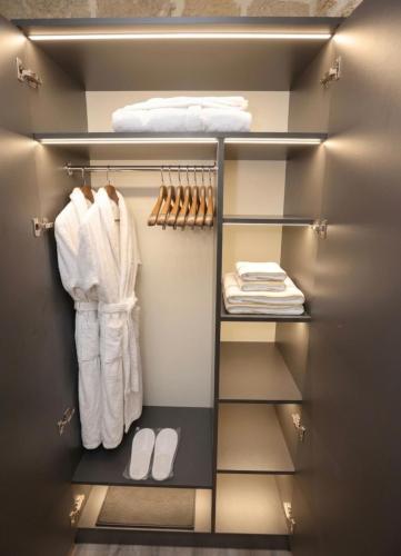 a walk in closet with white towels and shoes at Green Garden Hotel in Baku