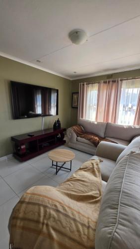 a living room with a couch and a table at The Manor in Manzini