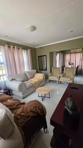 a living room with two couches and a couch at The Manor in Manzini