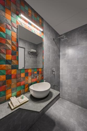 a bathroom with a large tub and a mirror at Hotel Fountain - Kamrej in Surat