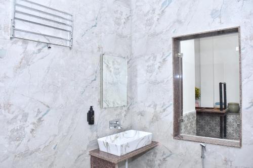 a white bathroom with a sink and a mirror at Nova Heaven Villa in Daijar
