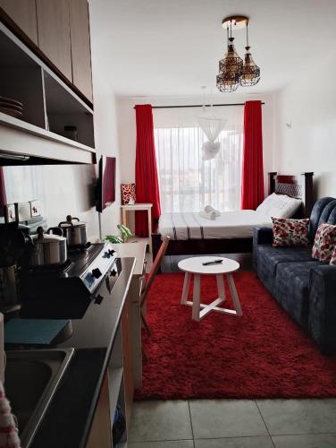 a kitchen and a living room with a couch and a table at Tsavo in Nairobi