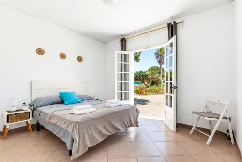 a bedroom with a bed and a sliding glass door at Casa Carlos - Villa en Son Cabrises in Cala Blanca