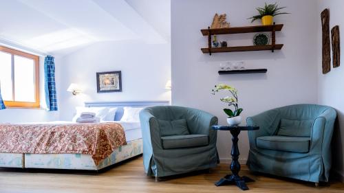 a bedroom with two chairs and a bed at Parkhotel Hohnstein by STEIGER Hotels in Hohnstein
