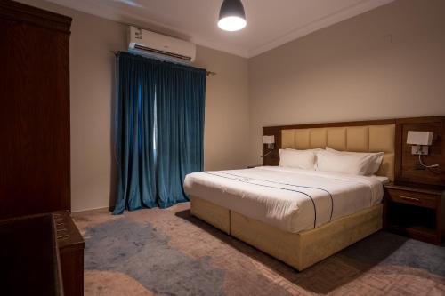 a bedroom with a large bed and a blue curtain at جولدن نيو السلامة GOLDEN NEW AlSALAMH in Jeddah
