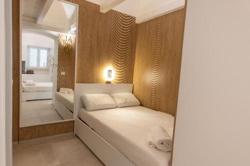 a small bedroom with a bed and a mirror at Luma Apartment Sperlonga in Sperlonga