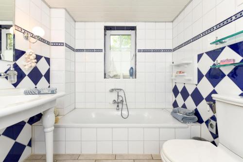 a bathroom with a tub and a sink and a toilet at Ferienhaus Sternenklar in Wittmund