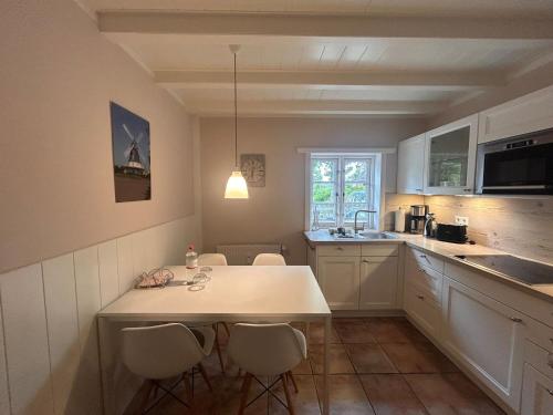 a kitchen with a table and chairs in it at Inseltraum in Wrixum