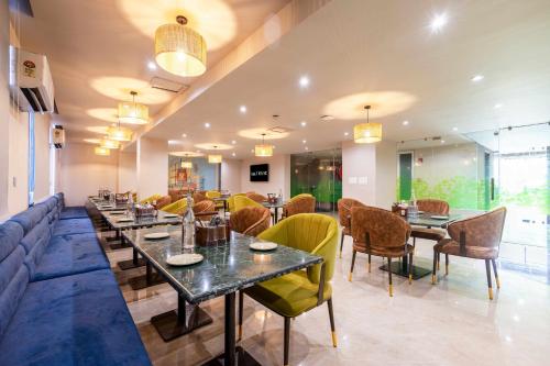 a restaurant with tables and chairs and a couch at Saltstayz Select- Medicity Near Medanta Hospital in Gurgaon
