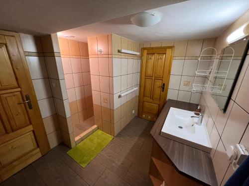 a bathroom with a sink and a shower and a mirror at Chata Pod Kohůtkou in Nový Hrozenkov