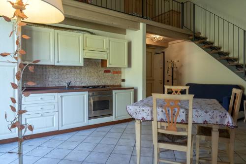 a kitchen with white cabinets and a table and a staircase at Hotel Residence Juvarra Centro Benessere in Biella
