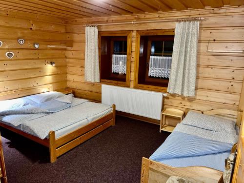 a bedroom with two beds in a log cabin at Chata Pod Kohůtkou in Nový Hrozenkov
