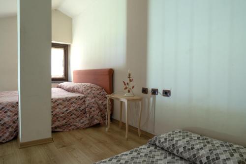 a room with two beds and a table in a room at Hotel Residence Juvarra Centro Benessere in Biella