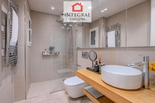 a bathroom with a white sink and a toilet at Apartament Eden Mar in Platja d'Aro