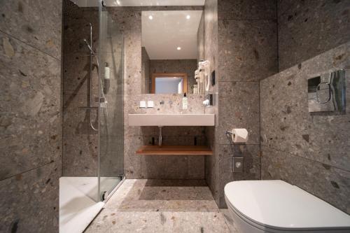 a bathroom with a shower and a toilet and a sink at Qubus Hotel Gliwice in Gliwice