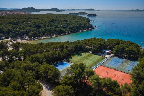 an aerial view of a tennis court and the water at Pine Beach Mobile homes all inclusive in Pakoštane