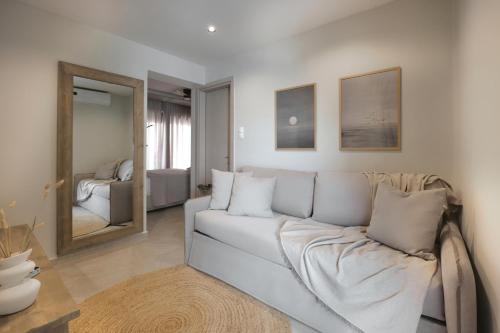 a living room with a white couch and a mirror at Sea Salt Skiathos in Skiathos