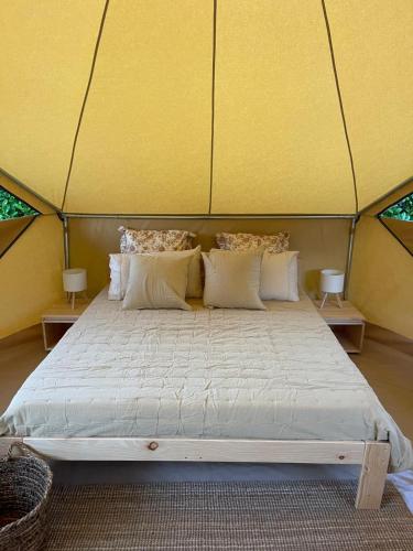 a large bed in a yurt with yellow walls at Camping Playa América Nigrán in Playa América