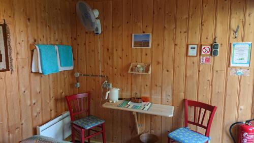 a room with two red chairs and a wooden wall at Countryside Eco Natuurhuisjes in Ee