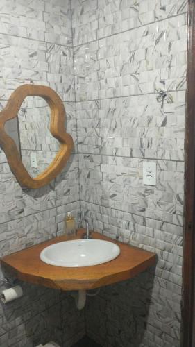 a bathroom with a sink and a mirror at Chalé Caminho Real in Itamonte