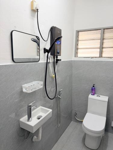 a bathroom with a shower and a toilet and a sink at Kuantan Tiny Homestay in Kuantan