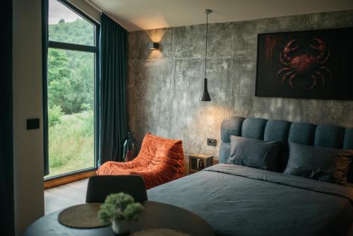 a bedroom with a blue bed and a large window at RAC by Zodiac Resort in Ceraşul